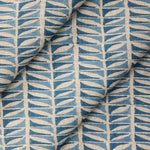 Draped close-up of fabric with a geometric leaf pattern in blue.