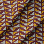 Draped fabric with a geometric pattern of triangles in yellow, and blue on a purple field.
