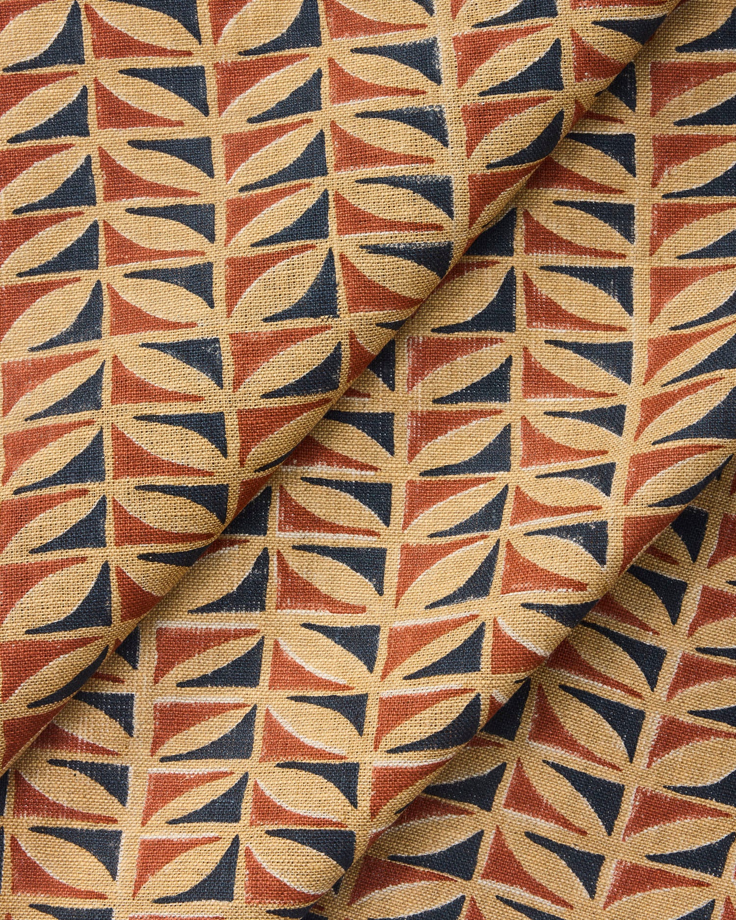 Draped fabric with a geometric triangle pattern in red, blue, and beige.