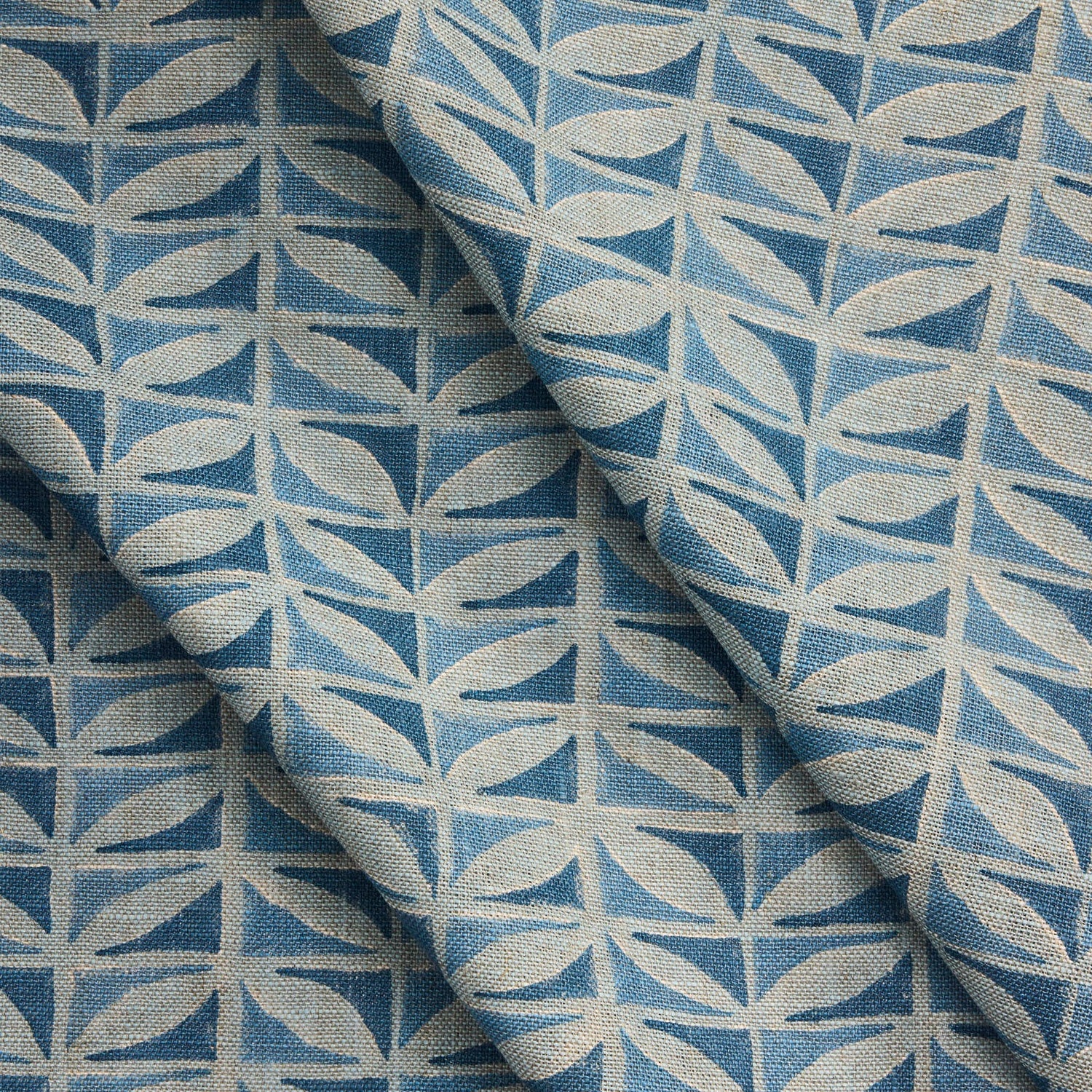 Draped close-up of fabric with a leaf pattern in shades of blue.