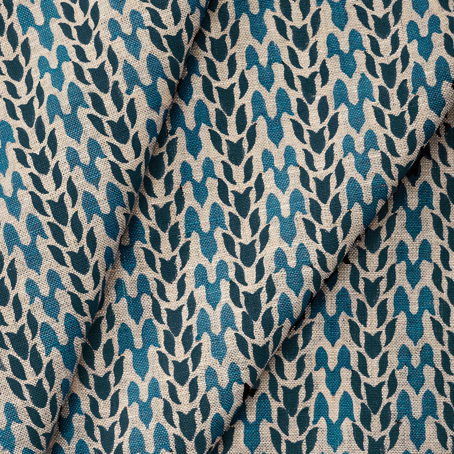 Draped fabric with abstract leaf pattern in shades of blue. 