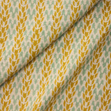 Draped fabric with a pattern of yellow and green leaves on a neutral background