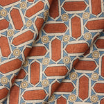 Draped fabric with geometric mosaic pattern of red, blue, and beige colors.