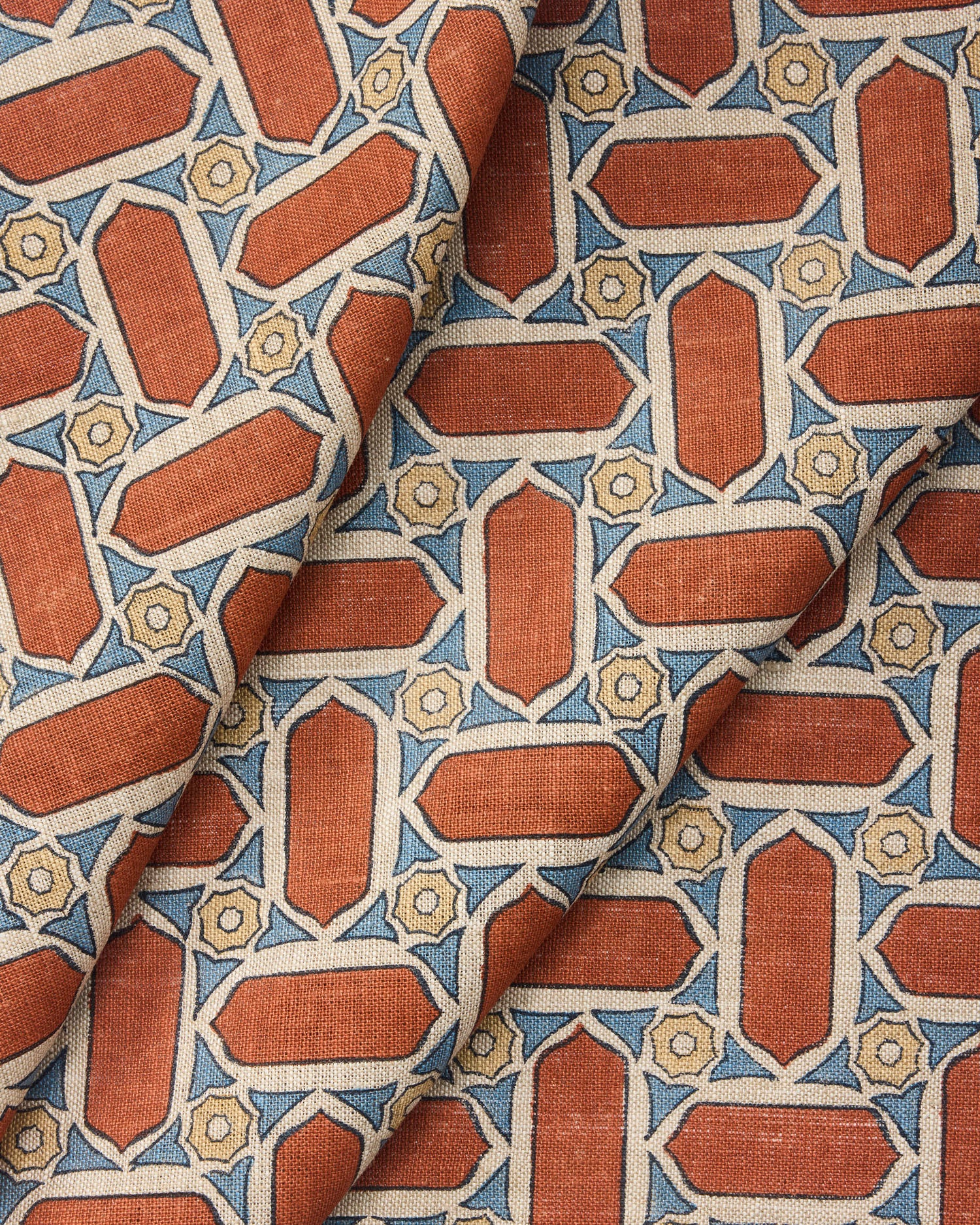 Draped fabric with geometric mosaic pattern of red, blue, and beige colors.