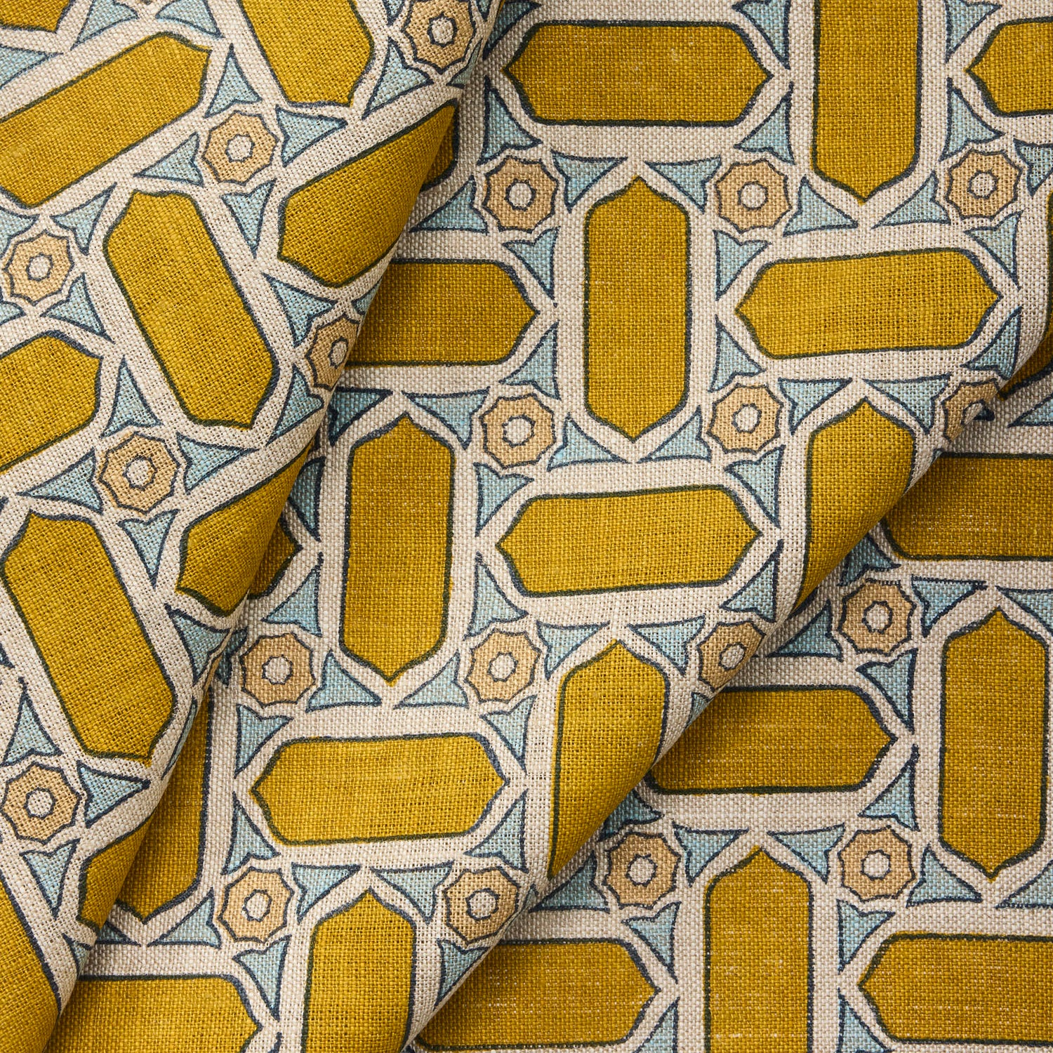 Close-up of draped fabric with geometric mosaic pattern in yellow and blue