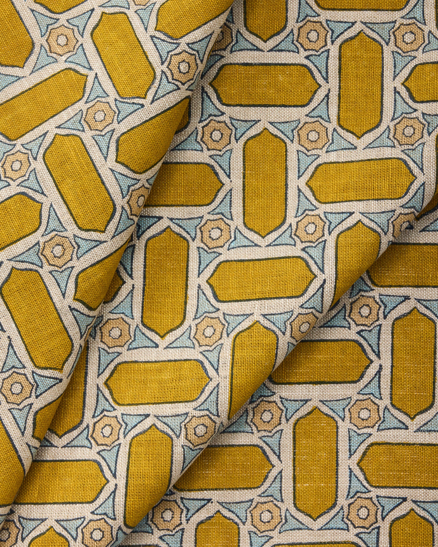 Close-up of draped fabric with geometric mosaic pattern in yellow and blue