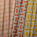 Three fabric swatches with geometric mosaic patterns in pink, red, and yellow.