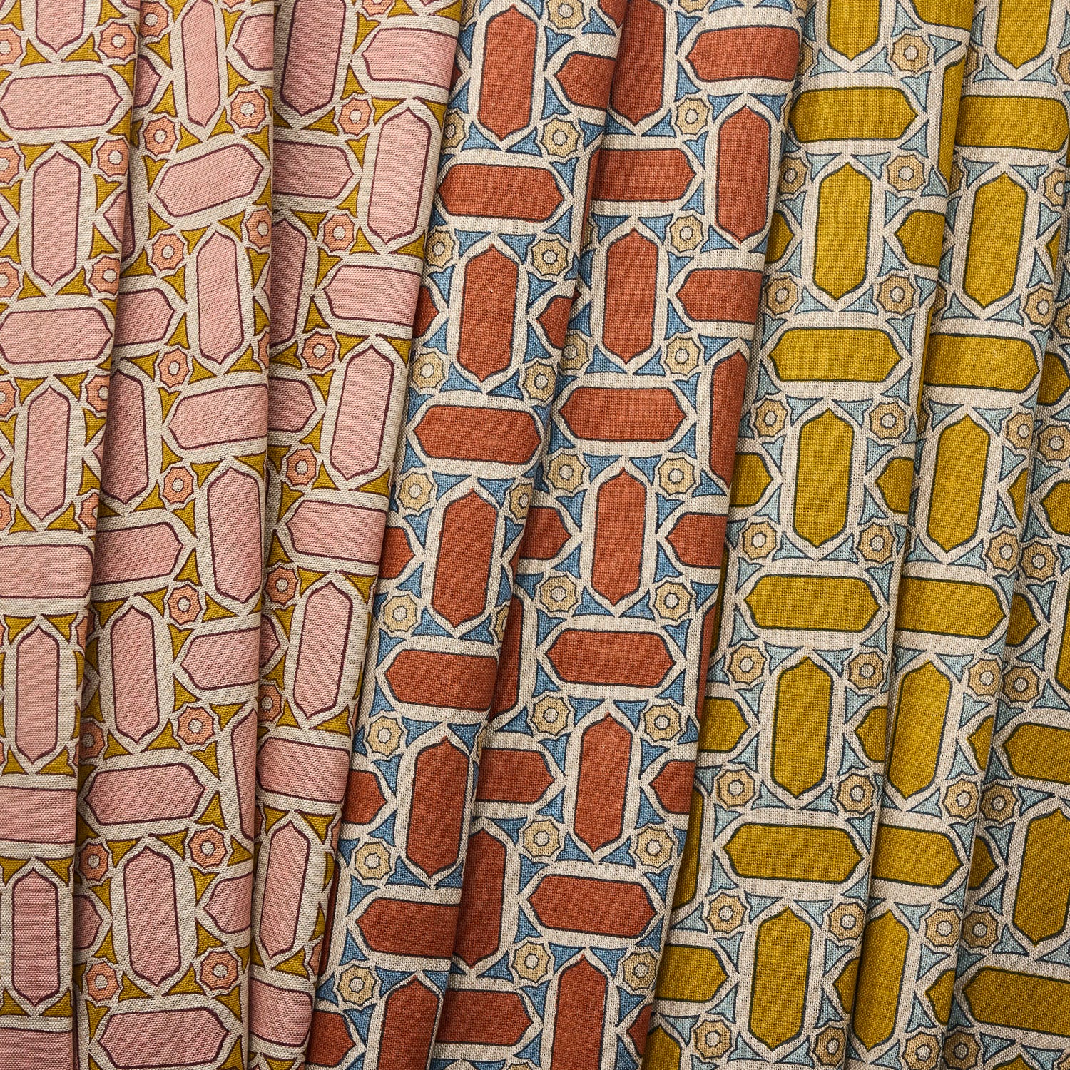 Three fabric swatches with geometric mosaic patterns in pink, red, and yellow.