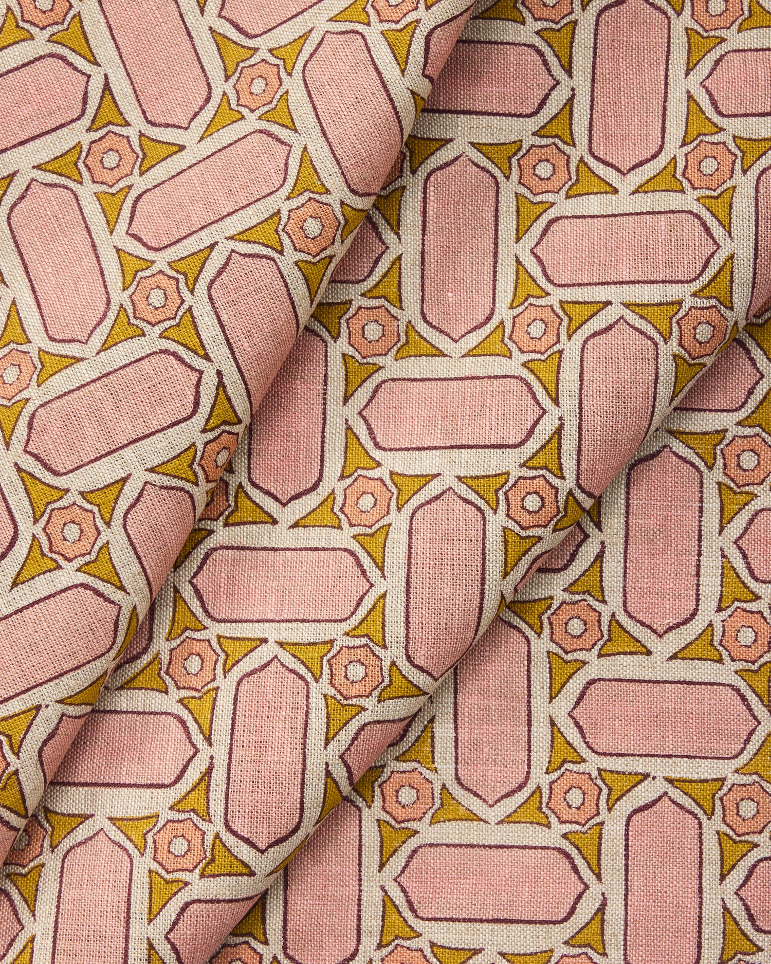 Draped fabric with geometric mosaic pattern of pink and green.