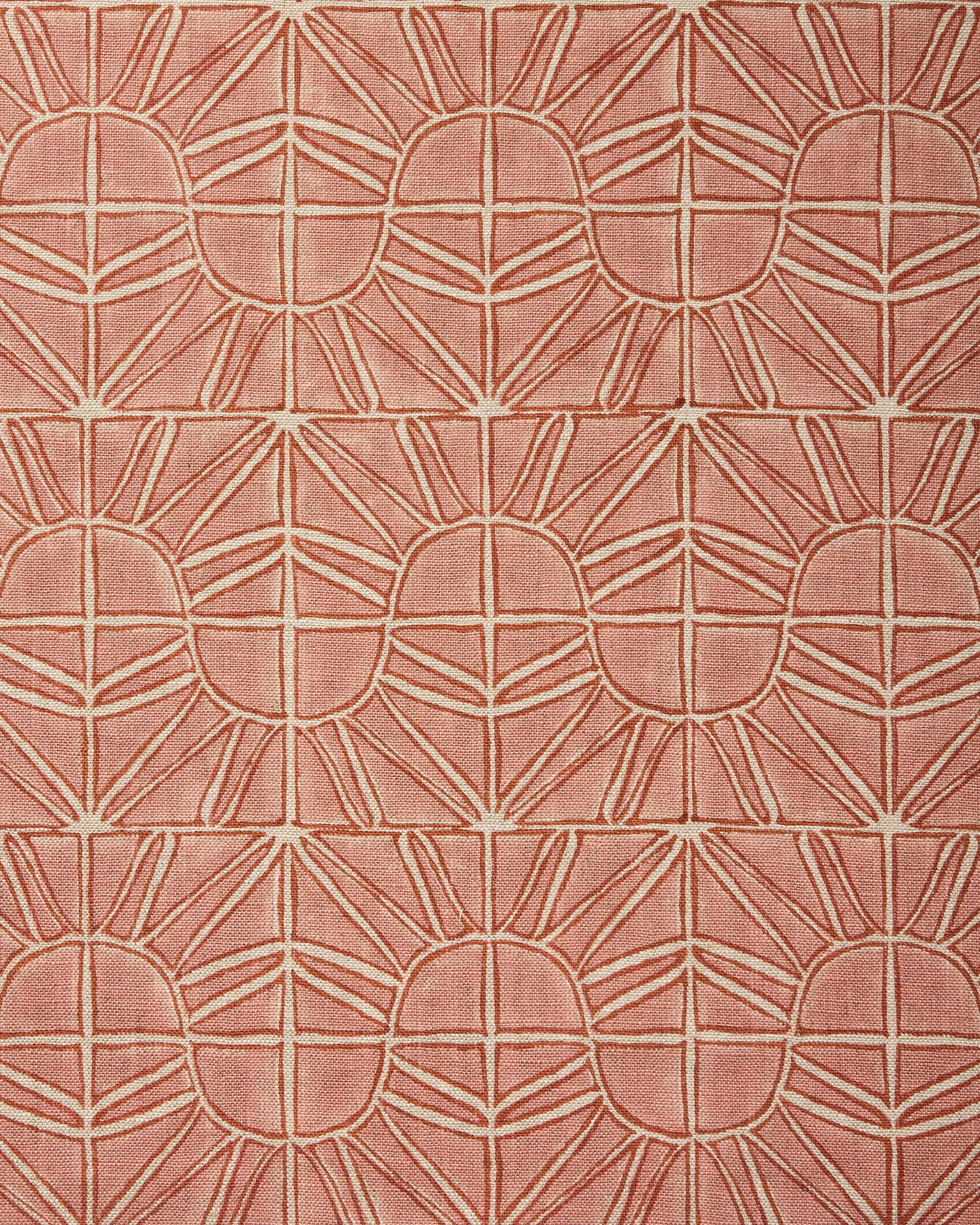 Fabric with geometric sun pattern in clay pink and rust red.