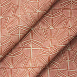 Draped fabric with geometric sun pattern  in clay pink and rust red.