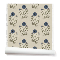 Partially unrolled wallpaper in a large-scale painterly floral print in blue and green on a cream field.
