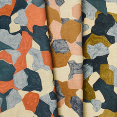 A group of draped woven fabrics, each in a different colorway of a painterly geometric pattern.
