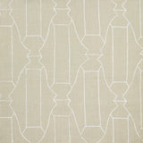 Woven fabric swatch in a repeating curvolinear print in white on a cream field.