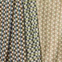 A group of draped woven fabrics, each in a different colorway of a repeating mosaic print.