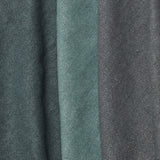 A group of folded linen swatches in various shades of dark green and gray.