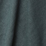 A draped swatch of old-world linen fabric in a solid dark green-gray color.