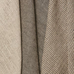 Group of three folded linen swatches in three different small-scale patterns, all in shades of tan and black.