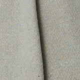 A draped swatch of blended linen-wool mix fabric in a flecked cream color with blue overtones.