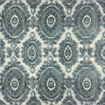 Detail of a handknotted rug with a floral medallion pattern in shades of acqua and grey. 