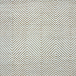 Detail of a handwoven rug in a chevron pattern in natural raffia and ivory yarn