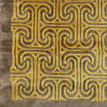 Detail of a handkotted rug in a classic greek key pattern in yellow on a brown field