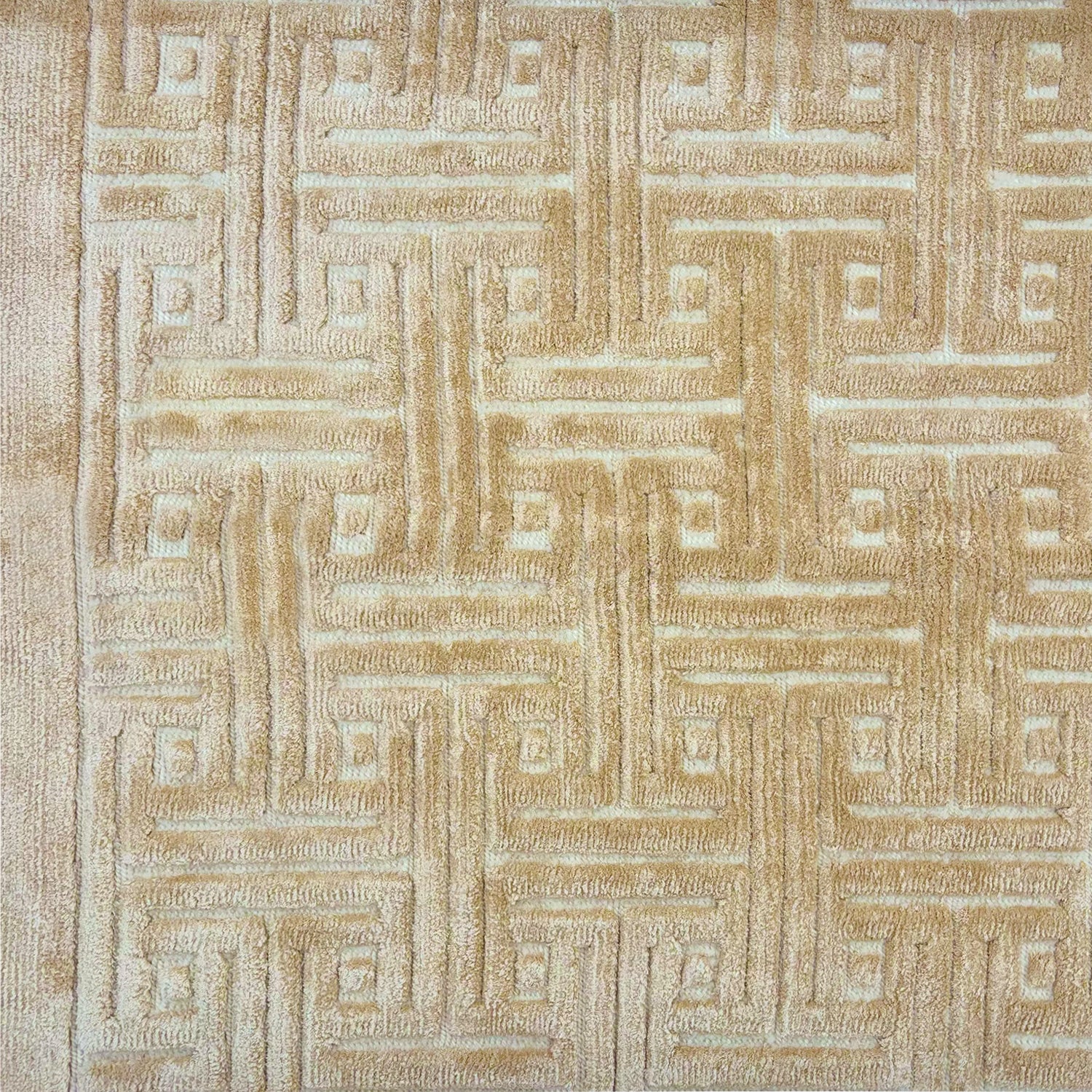 Detail of a handknotted rug with a greek key inspired pattern in shades of cream