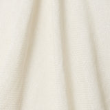 A draped swatch of open-weave sheer interior fabric in a cream color.