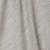 A draped swatch of open-weave sheer interior fabric in a mottled light gray color.