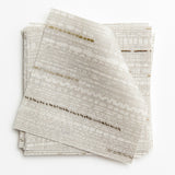 A stack of fabric swatches in a textural striped pattern in shades of gray, cream and tan.