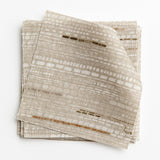 A stack of fabric swatches in a textural striped pattern in shades of white, cream and gray.