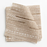 A stack of fabric swatches in a textural striped pattern in shades of cream and tan.