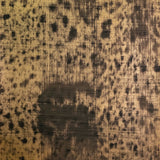 Detail of wallpaper in an absract texutral print in shades of metallic gold and black.