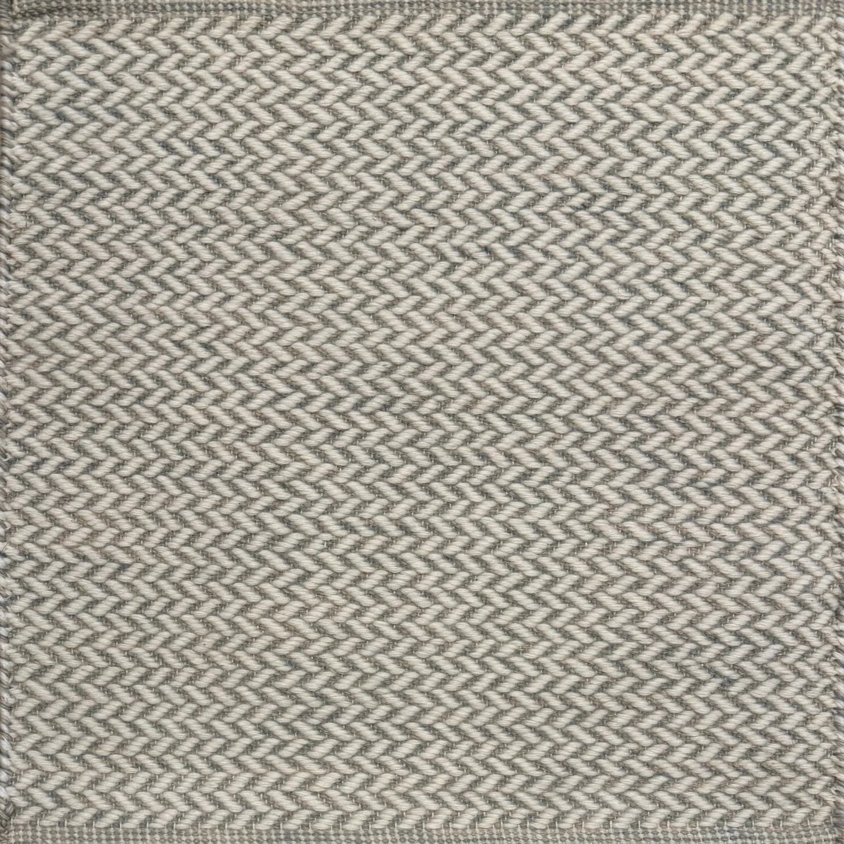 Textured rug with a herringbone pattern in white and grey