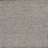 Textured rug with a herringbone pattern in white and dark grey.