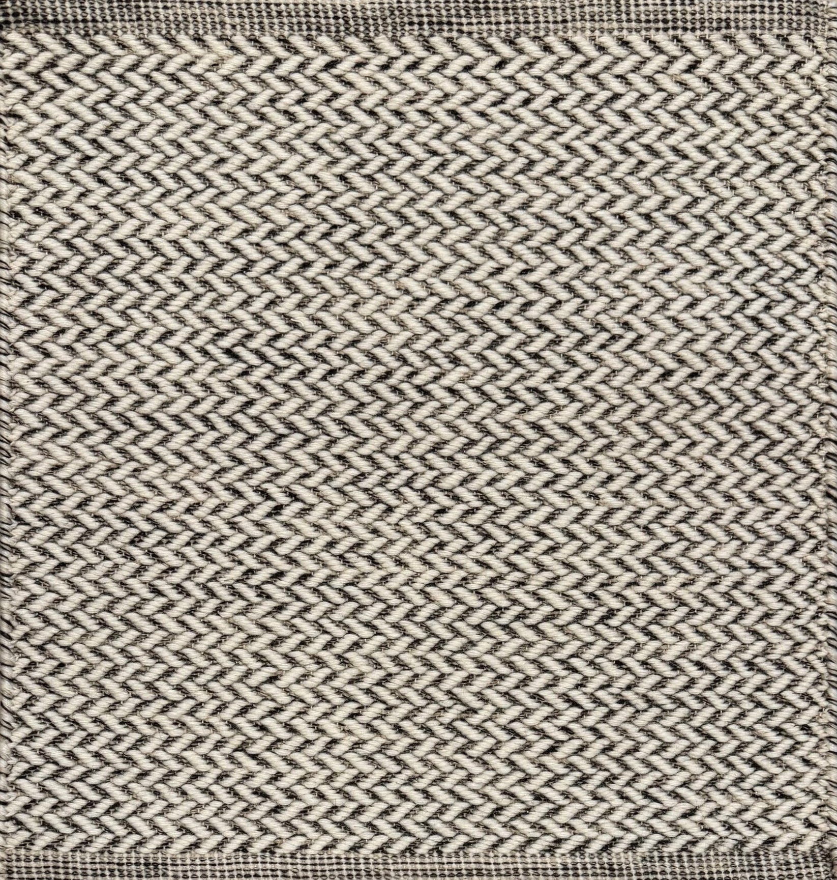 Textured rug with a herringbone pattern in white and charcoal grey