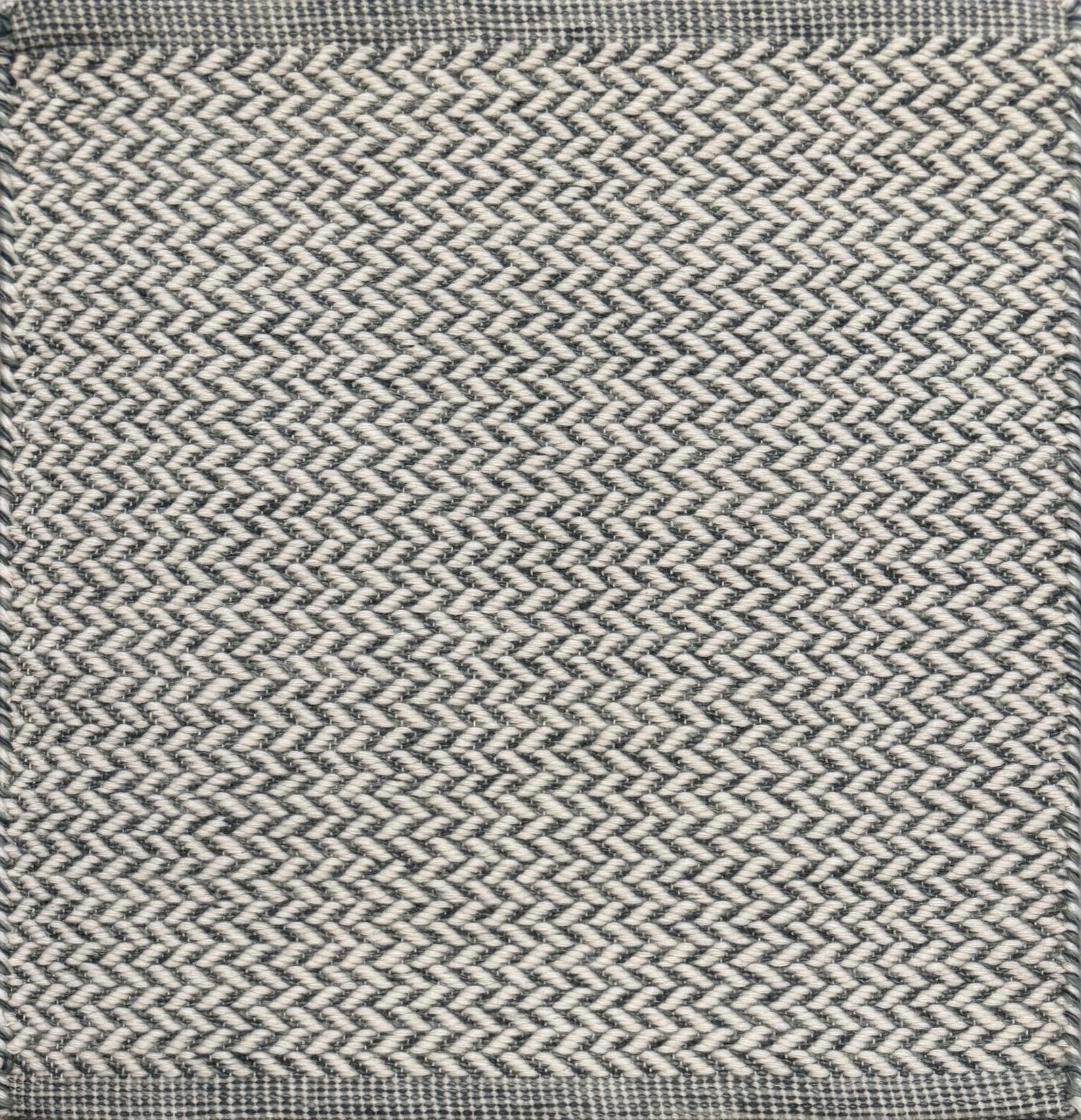 Textured rug with a herringbone pattern in white and slate blue. 