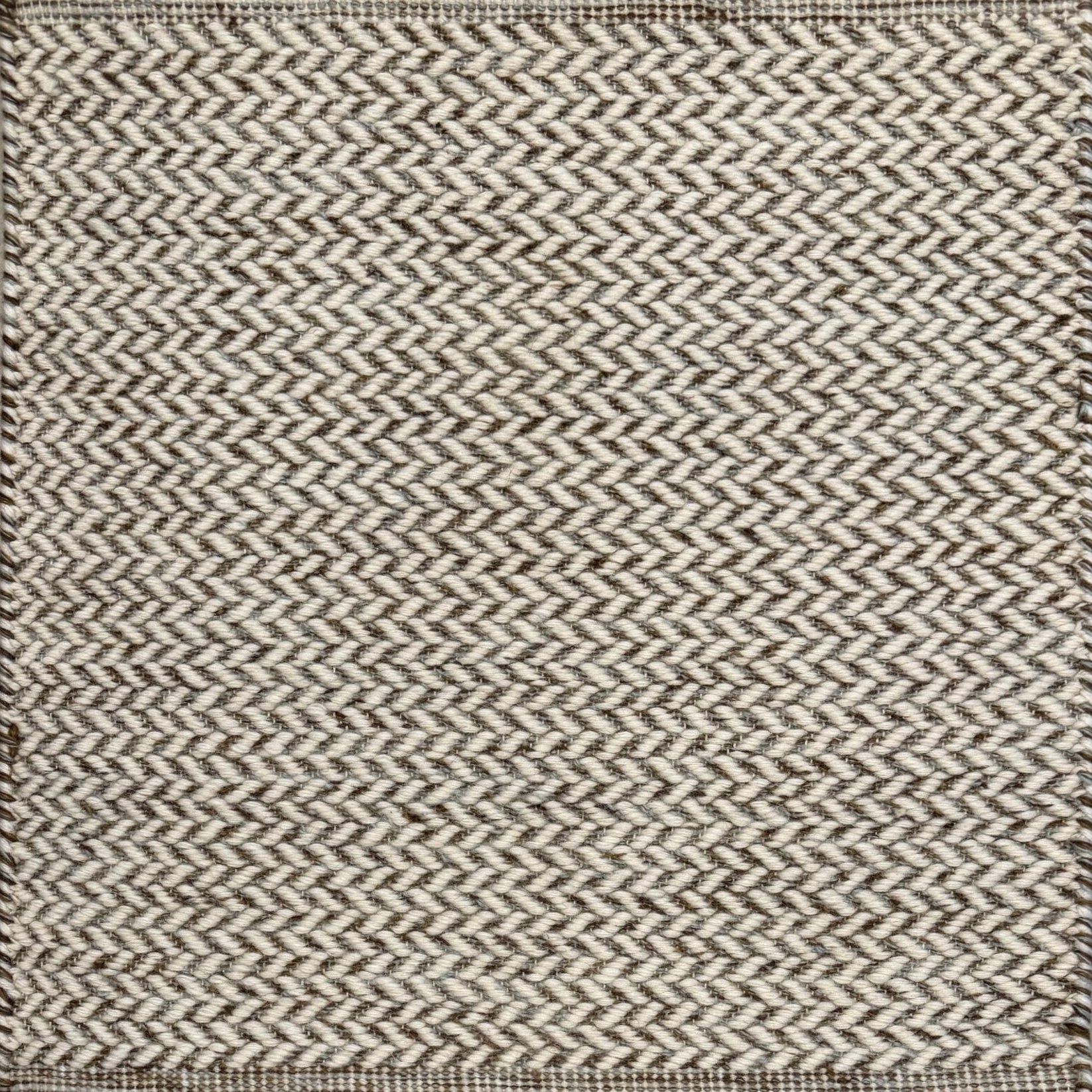 Textured rug with a herringbone pattern in white and brown.