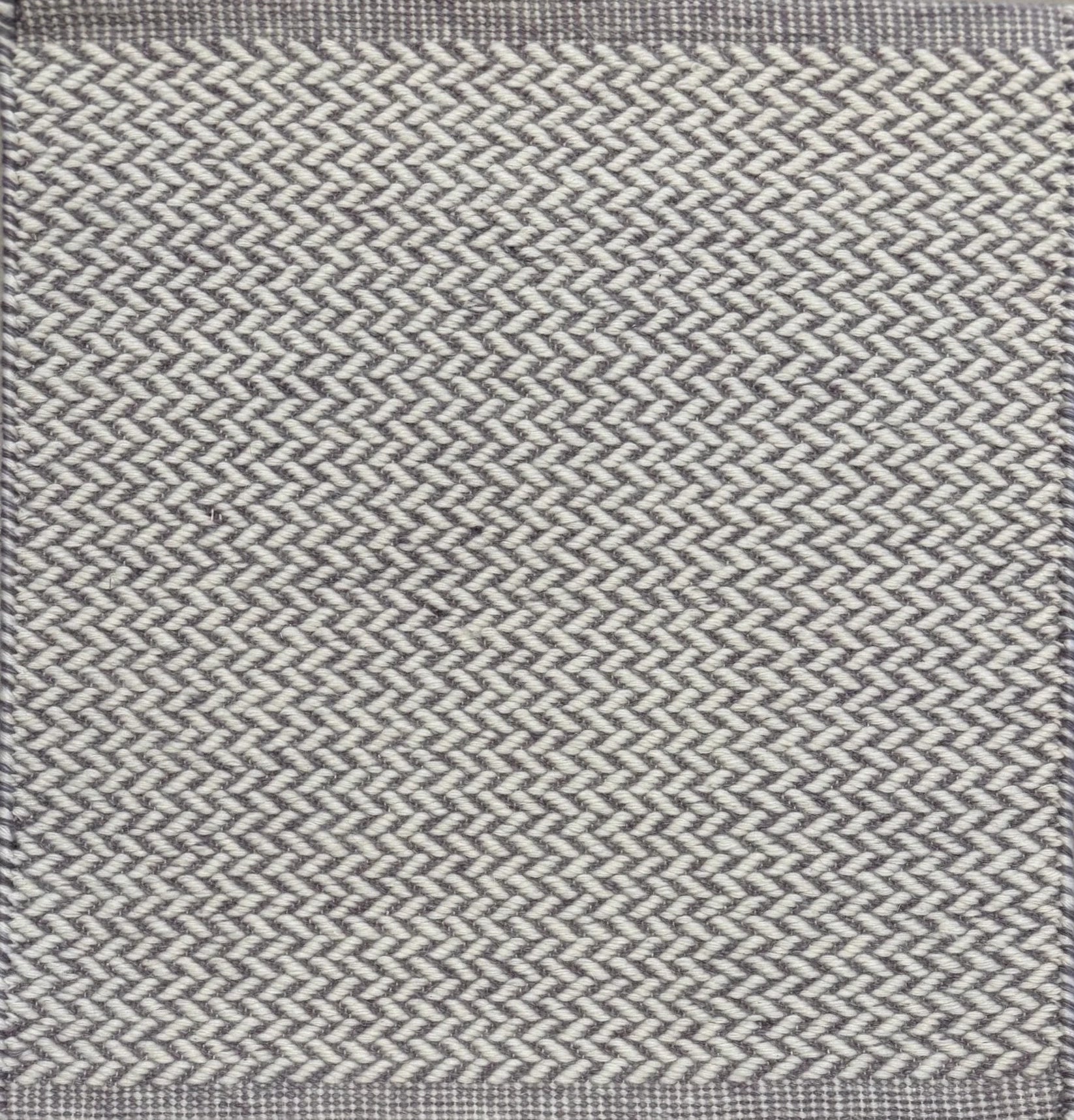 Textured rug with a herringbone pattern in white and light purple