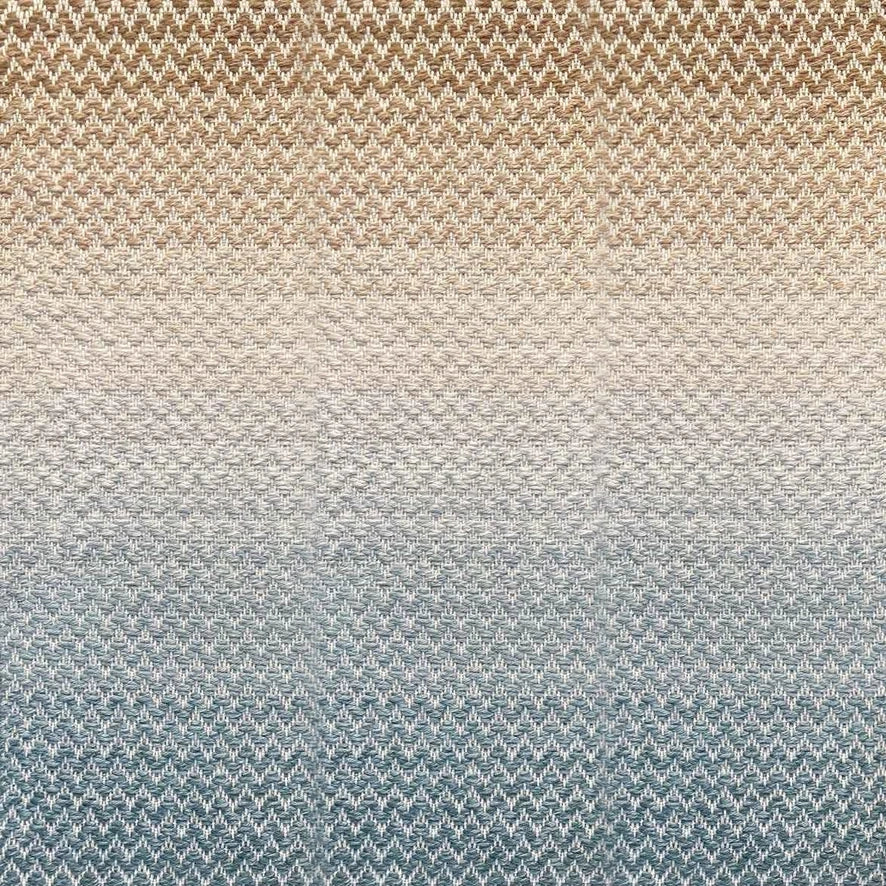 Broadloom carpet in a herringbone pattern in a subtle ombré color from teal blue to warm sand.