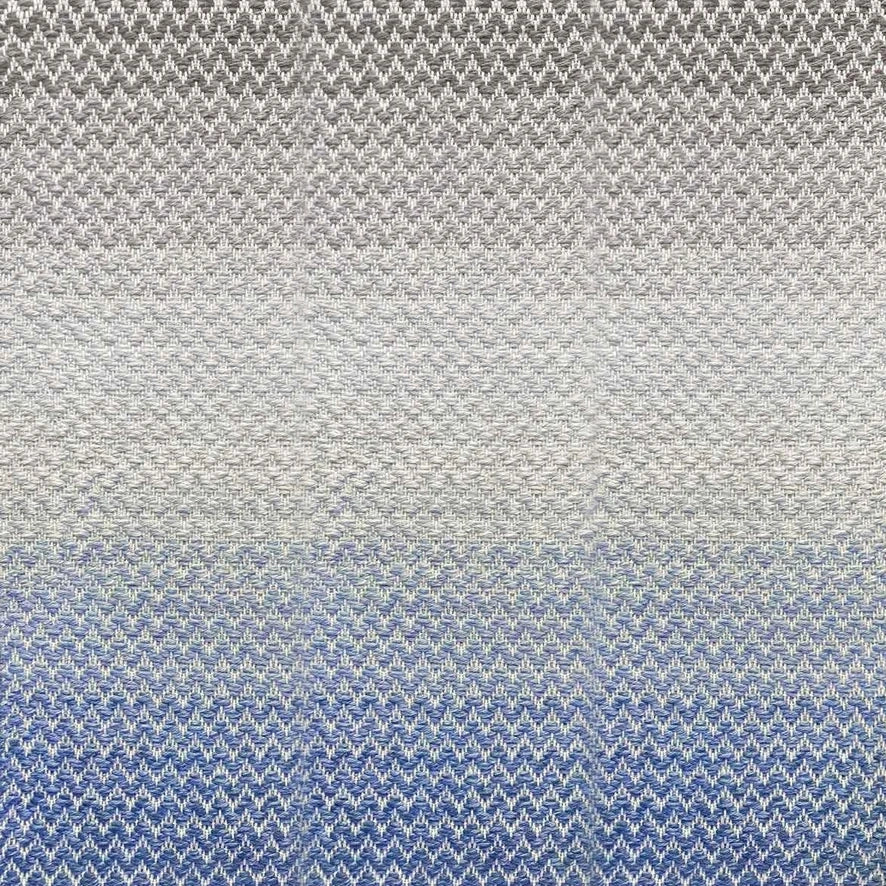 Broadloom carpet in a herringbone pattern in a subtle ombré color from bright blue to soft grey.