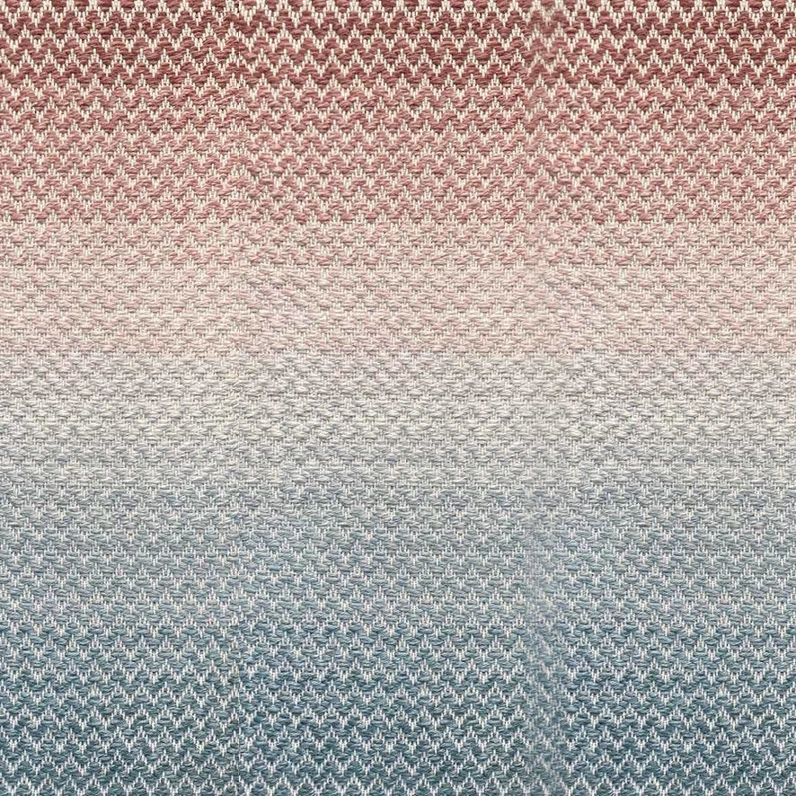 Broadloom carpet in a herringbone pattern in a subtle ombré color from teal blue to terracotta red.