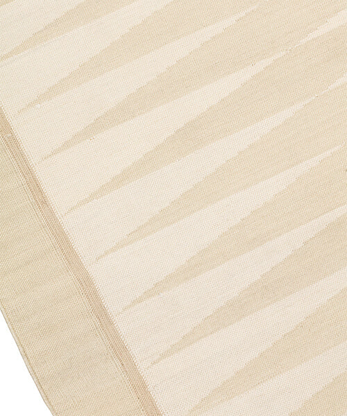 Handwoven rug in a geometric design in shades of beige. 