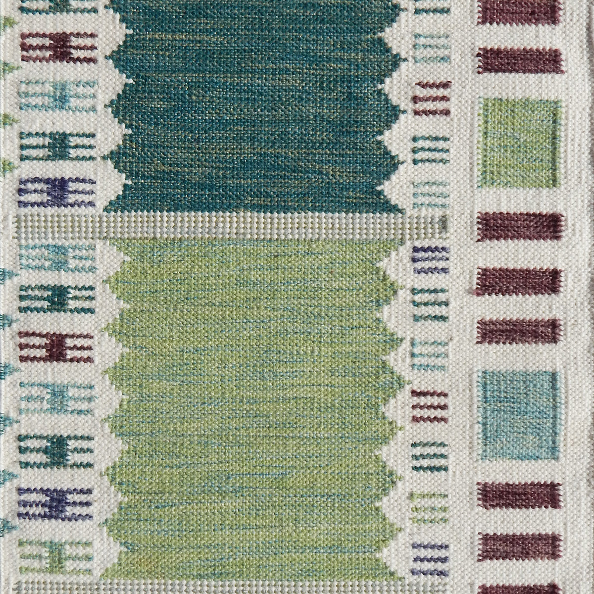 Handwoven rug detail in a Swedish checkerboard design shades of green and teal with white and brown accents. 