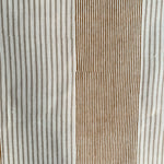 Detail of fabric in an irregular stripe print in rust and tan on a white field.