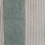 Detail of fabric in an irregular stripe print in green and brown on a white field.