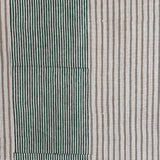 Detail of fabric in an irregular stripe print in green and brown on a white field.