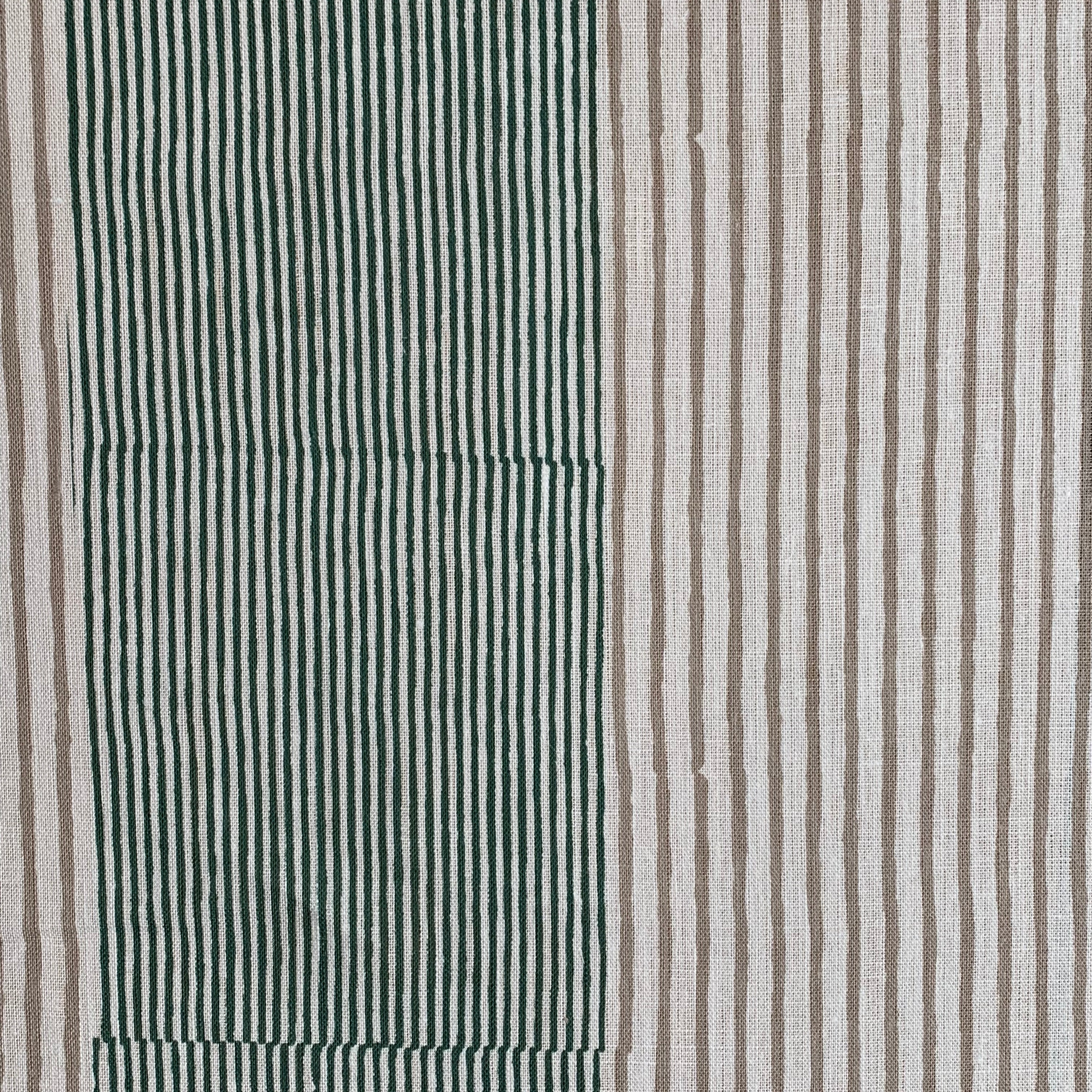 Detail of fabric in an irregular stripe print in green and brown on a white field.