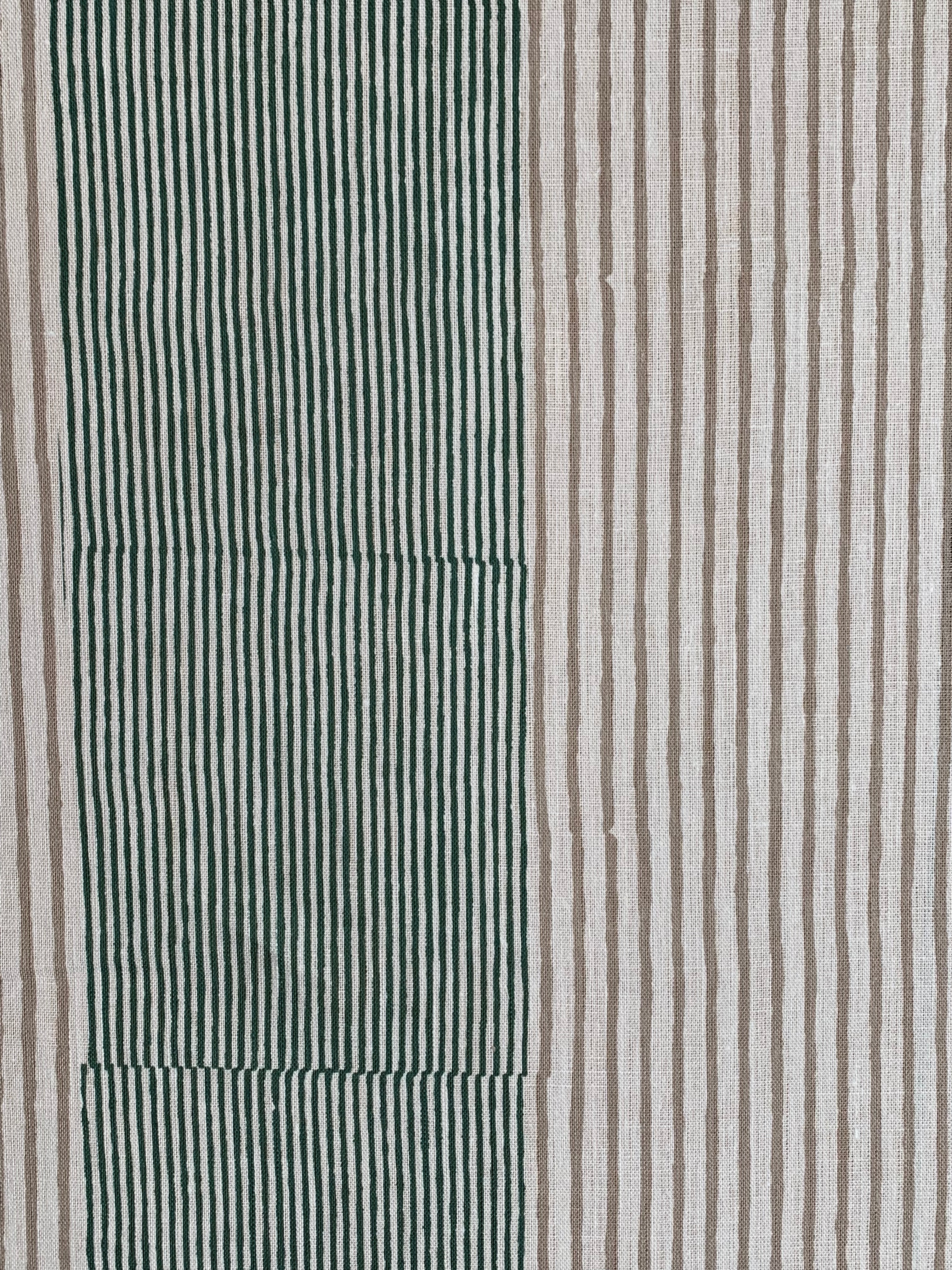 Detail of fabric in an irregular stripe print in green and brown on a white field.