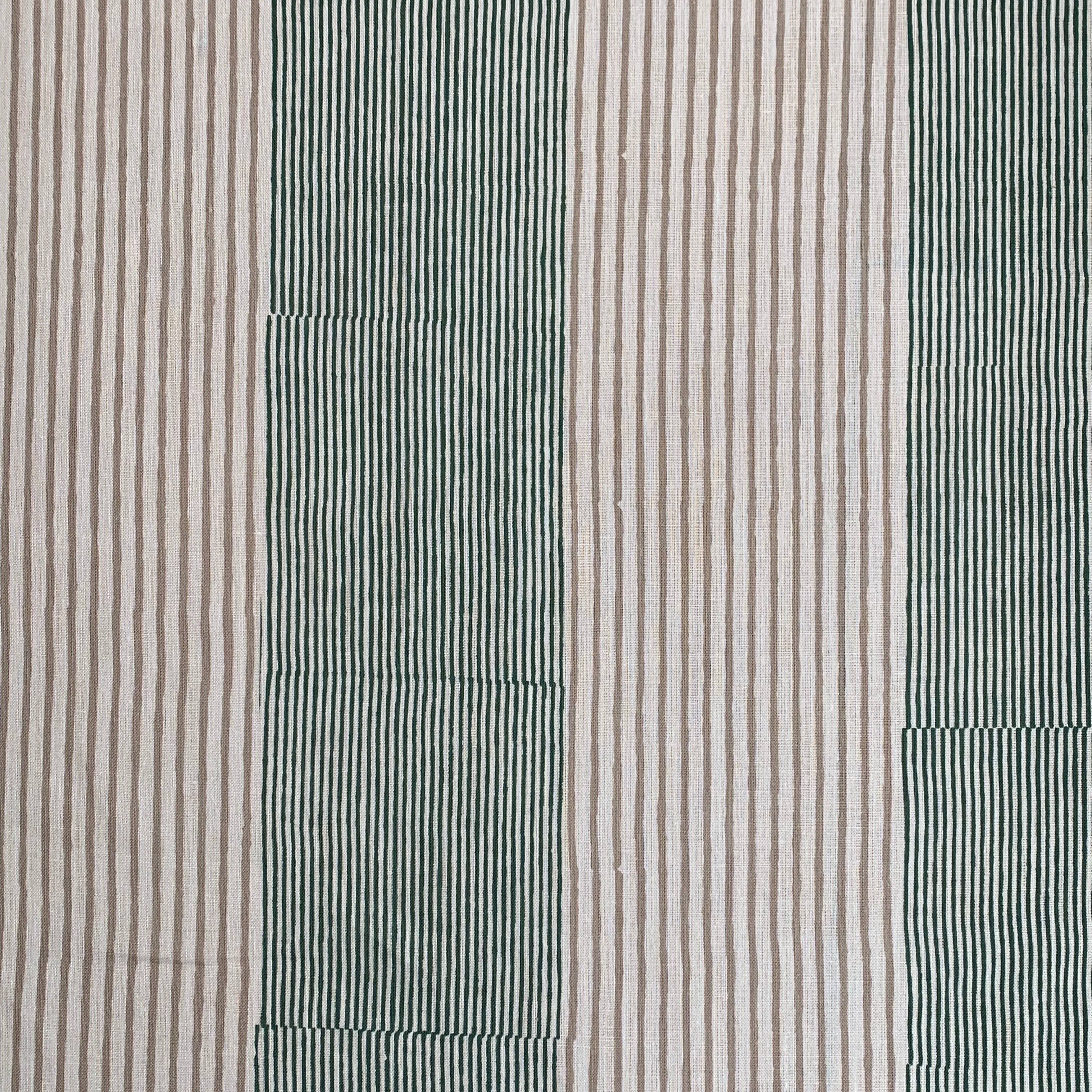 Detail of fabric in an irregular stripe print in green and brown on a white field.